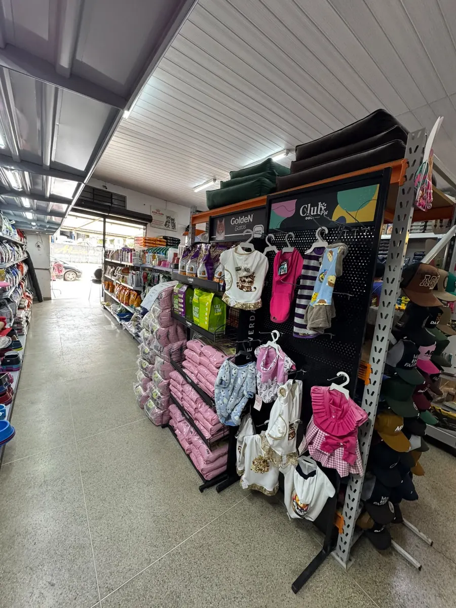 Roupinhas para pets e caminhas ao lado das rações para gatos